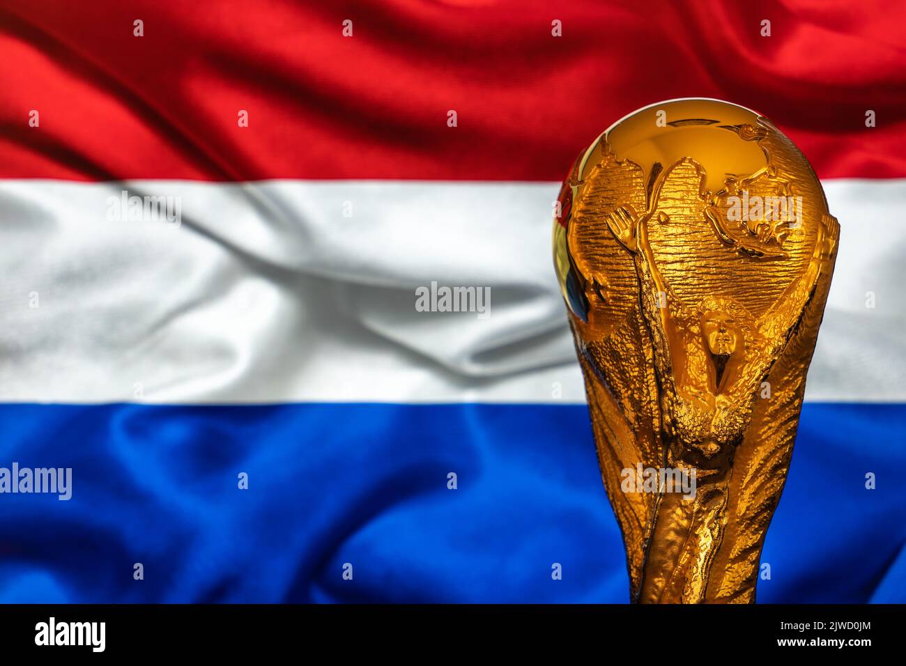 Doha, Qatar - September 4, 2022: FIFA World Cup trophy against the background of Netherlands flag. Stock Photo