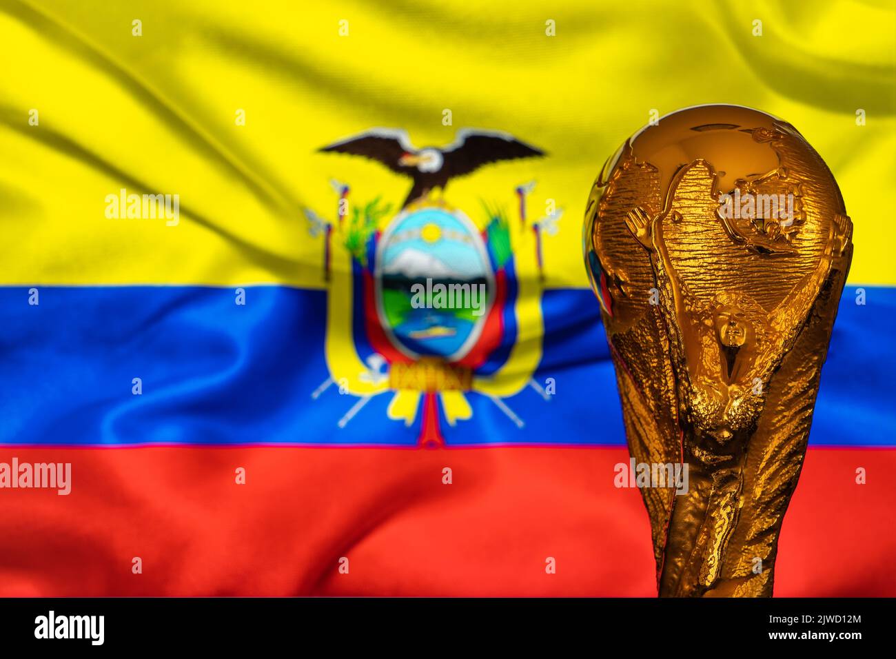 Doha, Qatar - September 4, 2022: FIFA World Cup trophy against the background of Ecuador flag. Stock Photo