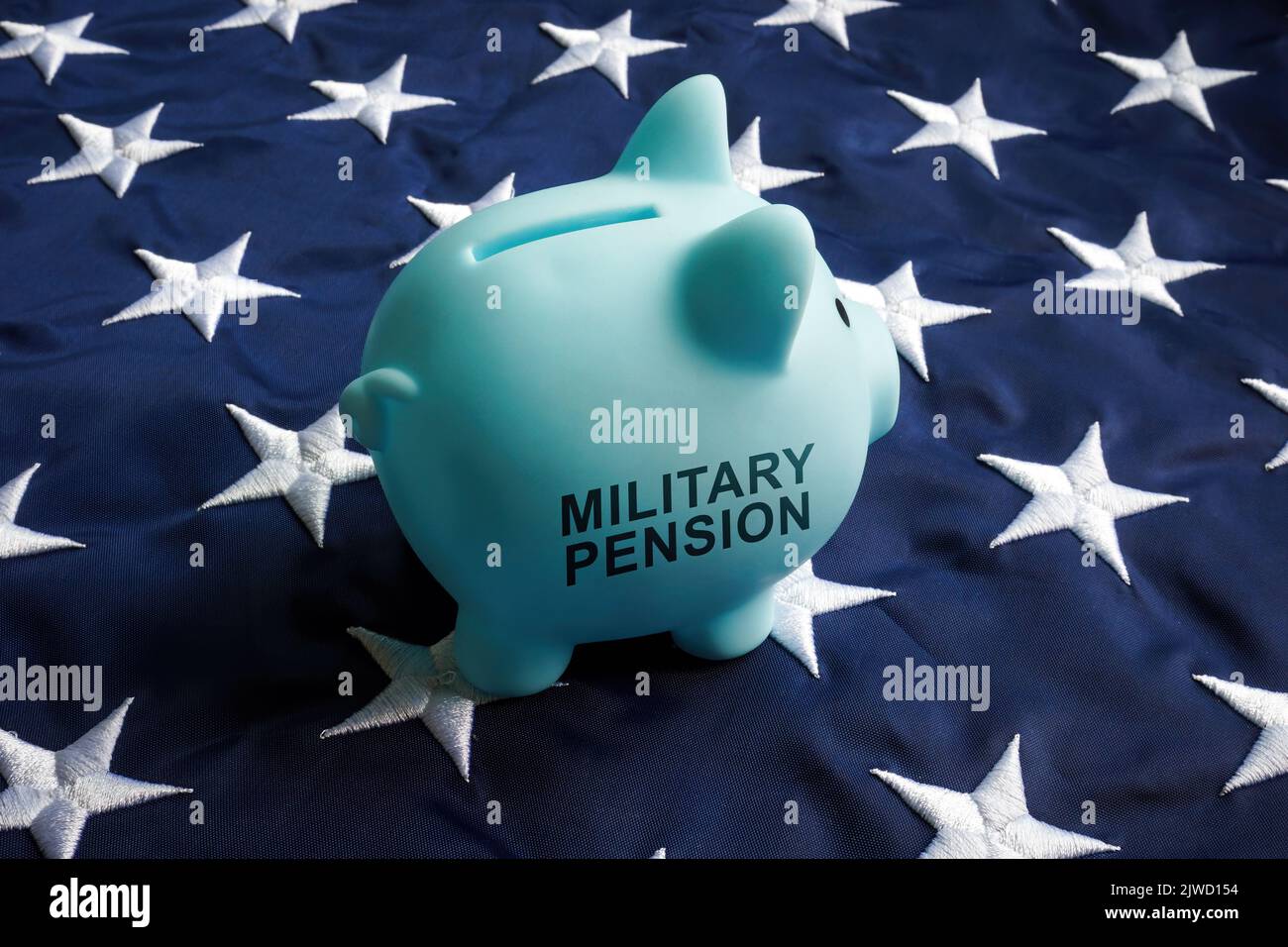 Military pension concept. Piggy bank with sign on a flag. Stock Photo