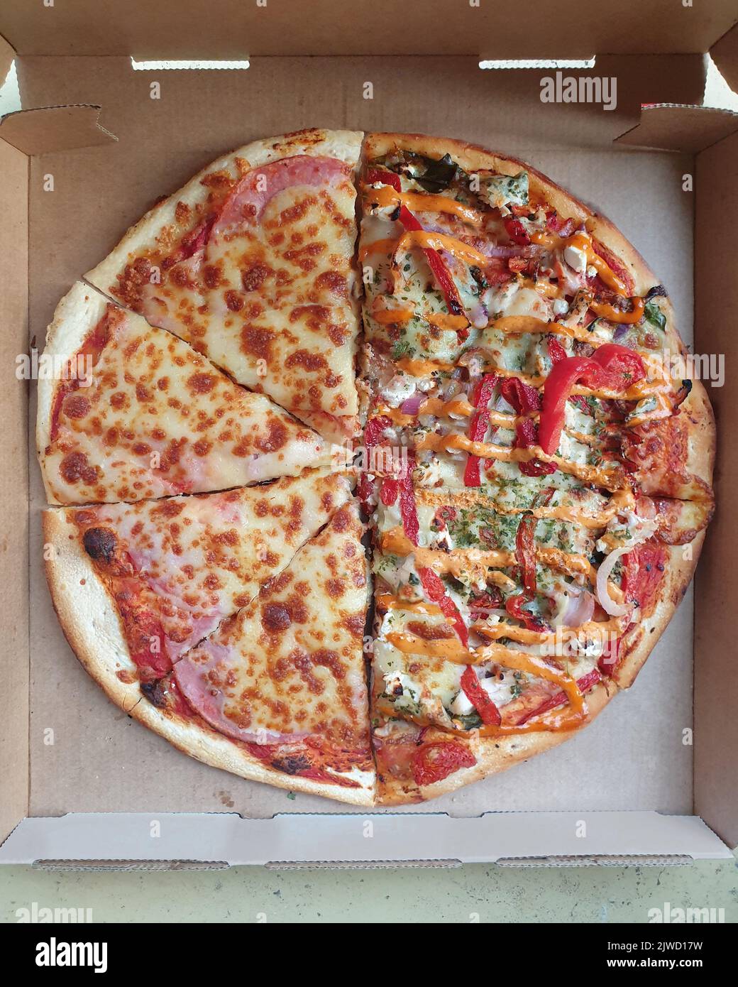 half and half pizza with two different toppings sliced in delivery box Stock Photo Alamy