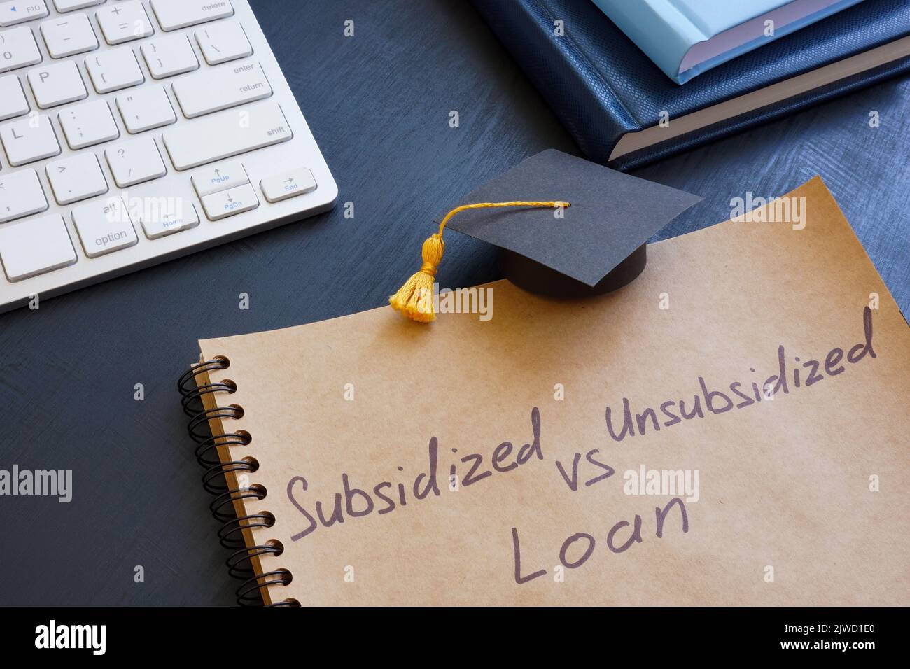 Sign Subsidized vs unsubsidized student loan and graduation cap. Stock Photo