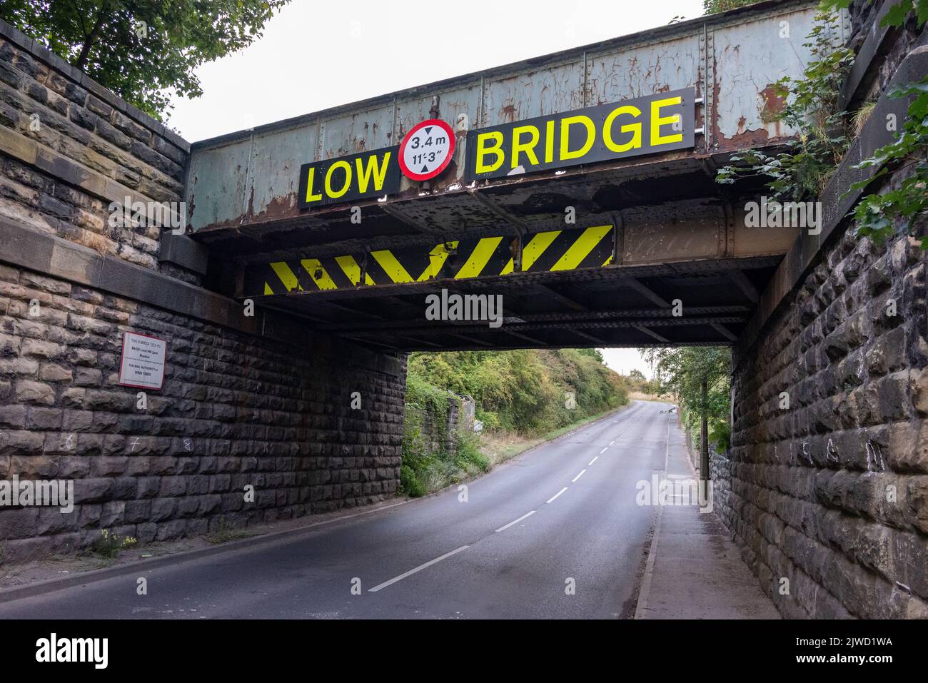 Low bridge warning sign on a railway bridge, UK Stock Photo