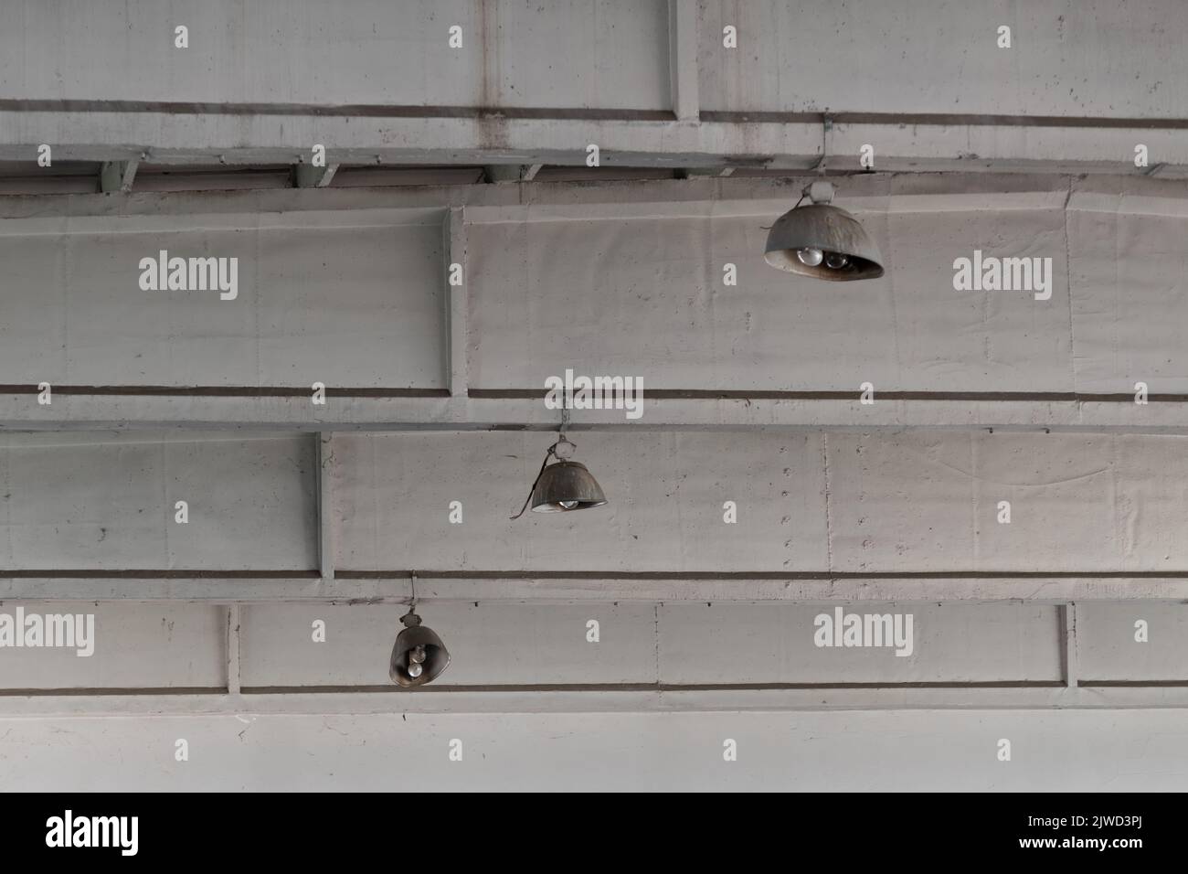 Ceiling lights in abandoned industrial building close up, urban exploration Stock Photo