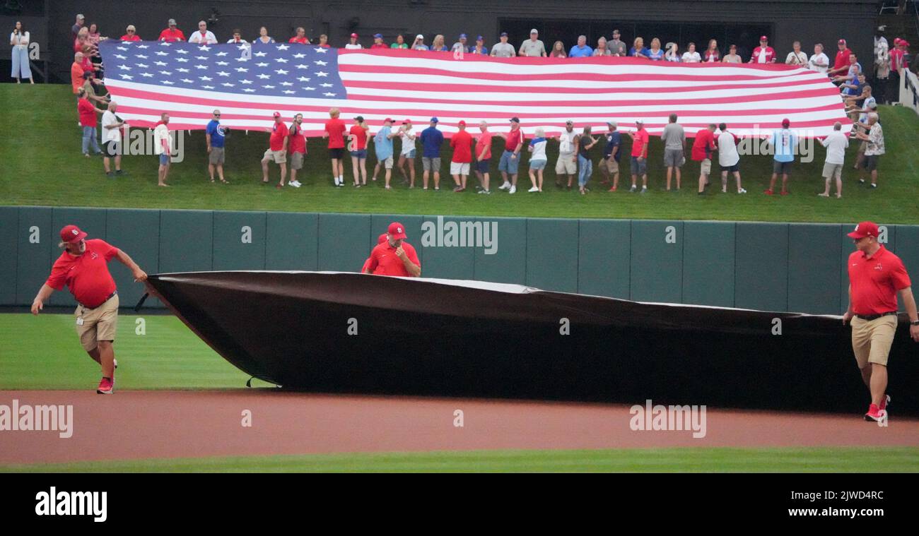 Members of the Busch Stadium field crew, pull the tarp across the infield as volunteers hold the American flag in center field for the National Anthem before the Chicago Cubs-St. Louis Cardinals baseball game at Busch Stadium in St. Louis on Sunday, September 4, 2022. The game began after a nearly two hour rain delay. Photo by Bill Greenblatt/UPI Stock Photo