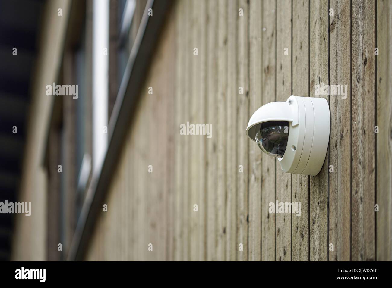 Round shaped weathersealed Security camera on the wooden wall Stock Photo
