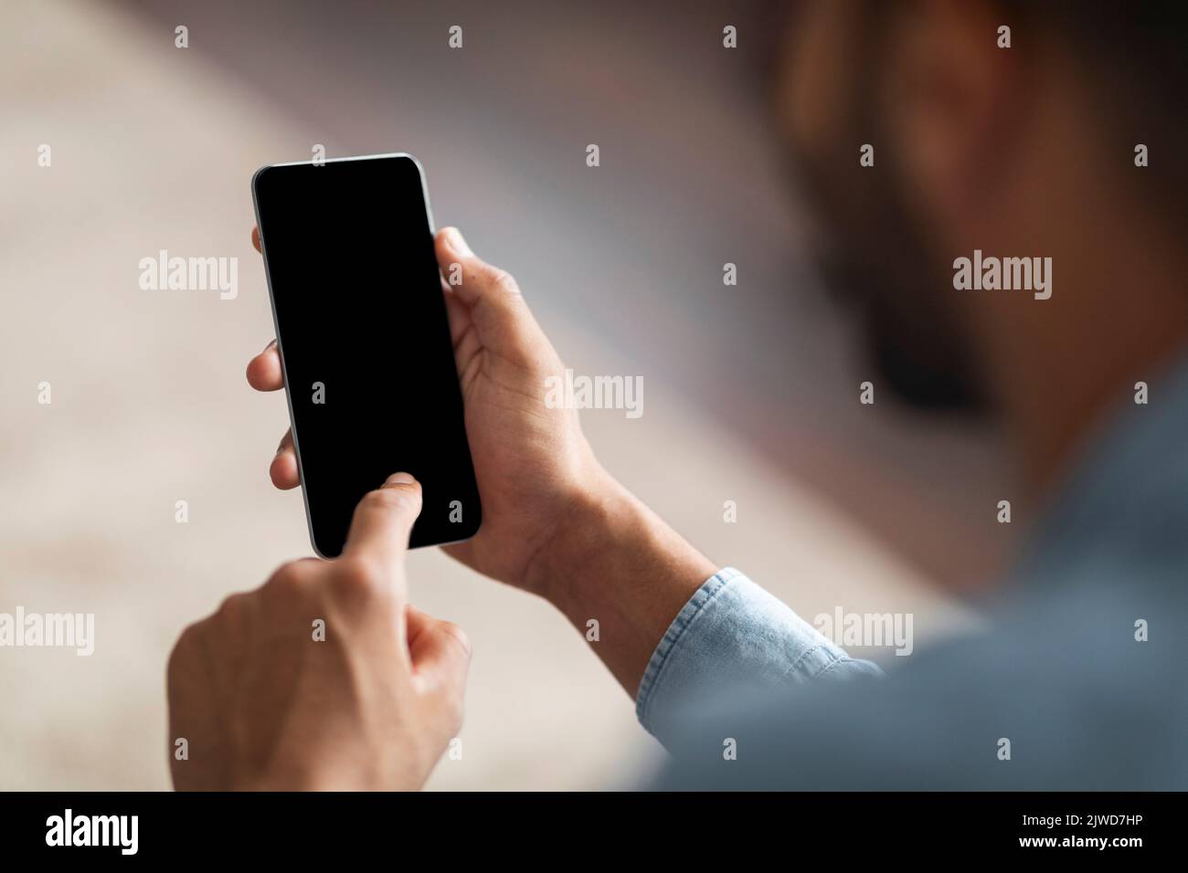 Unrecognizable Black Man Using Smartphone With Blank Indoors, Mockup Stock Photo