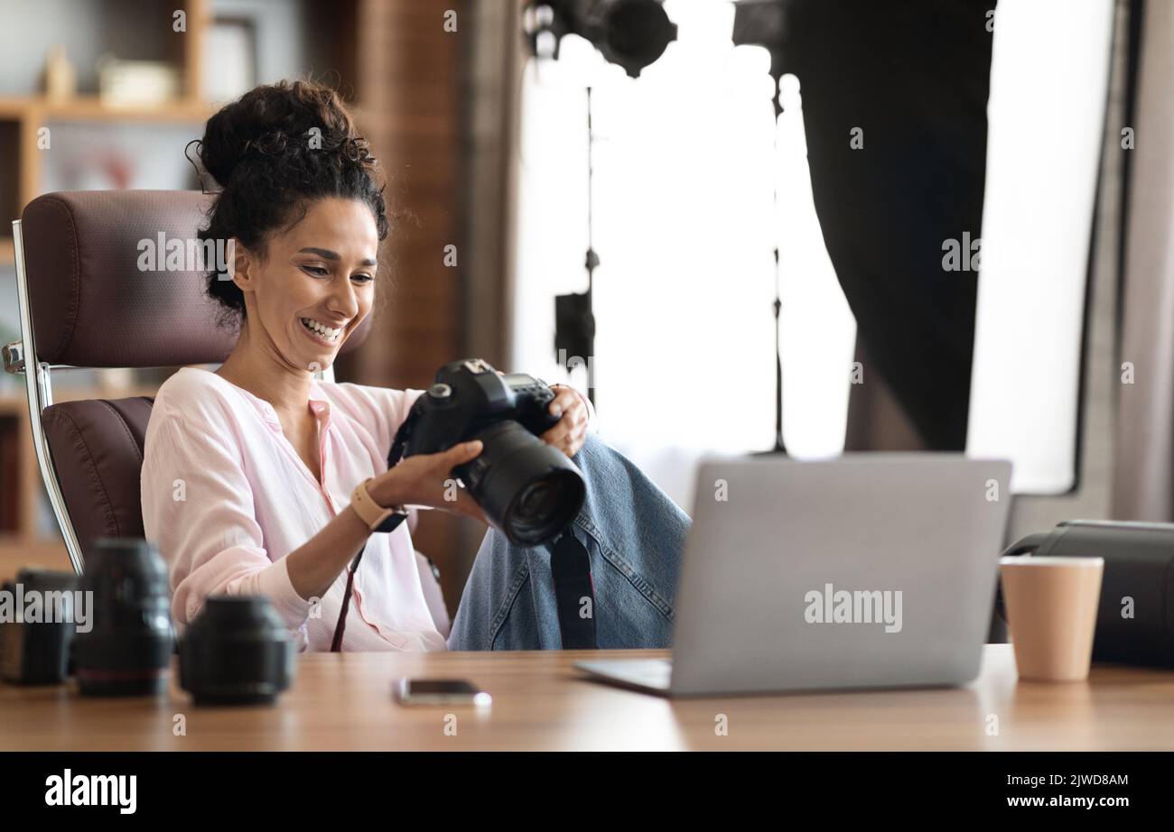Beautiful creative woman photographer working, using laptop and camera Stock Photo