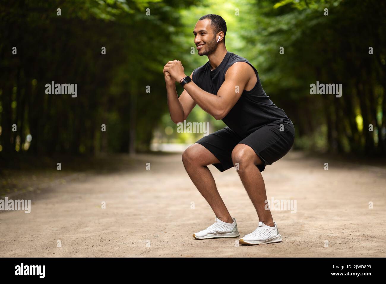 Positive middle eastern guy having workout at public park Stock Photo