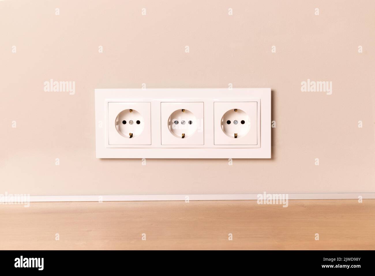Group of white european electrical outlets on modern neutral beige wall