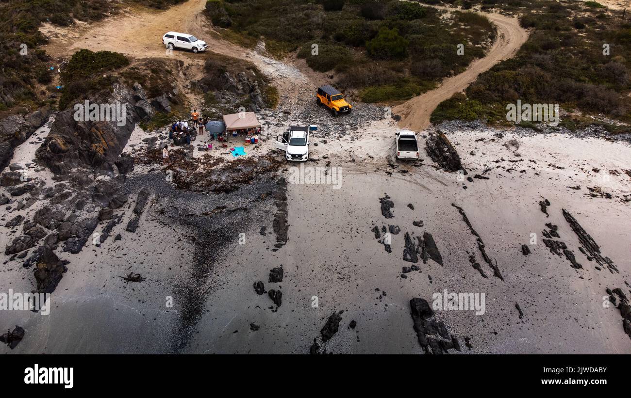 An aerial of the cars coming from the woody road to the deserted place in West Coast, South Africa. Stock Photo