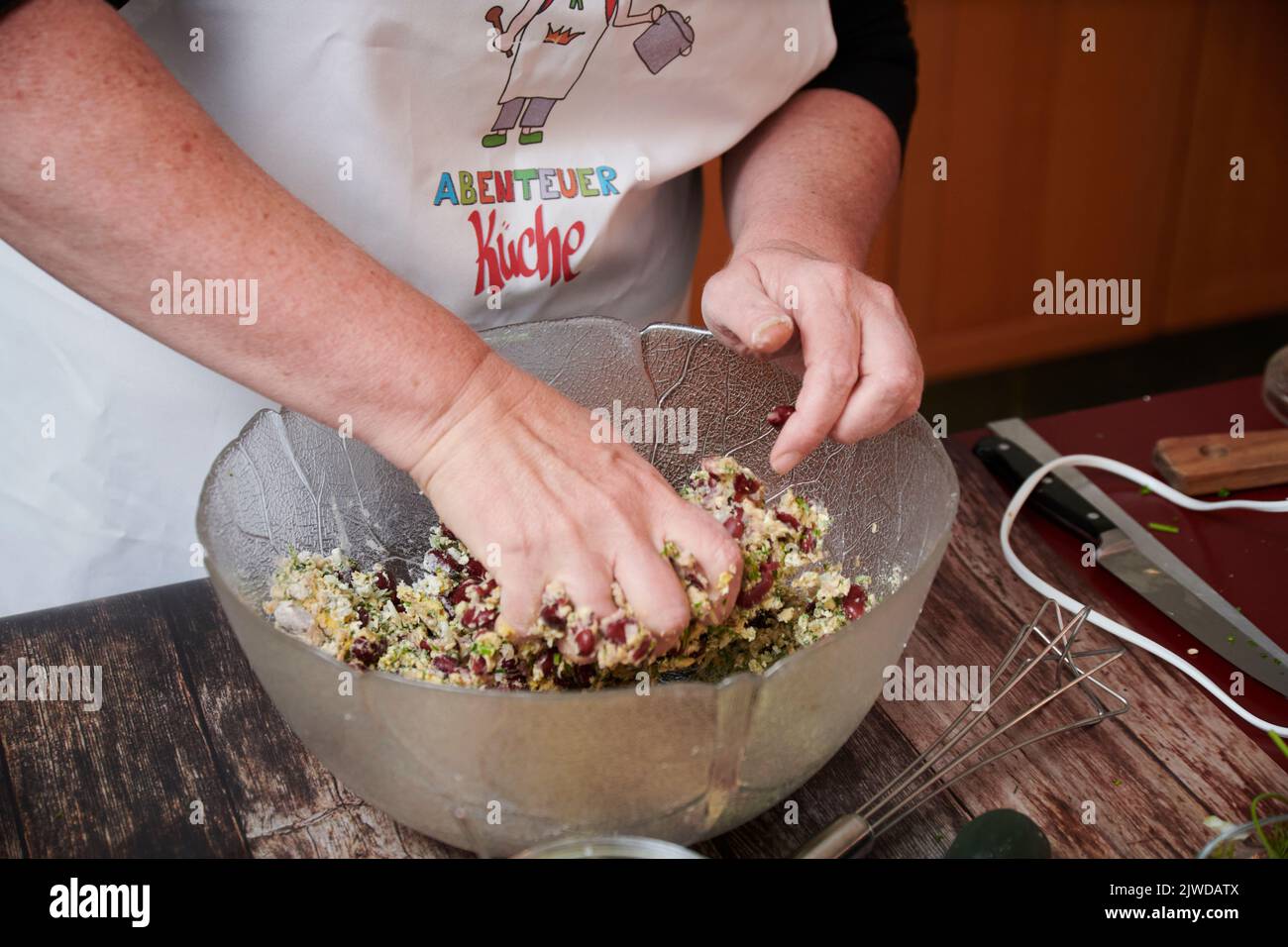 Herstellen einer Masse fuer vegetarische Bratlinge aus Kidneybohnen, Johannisbrotkernmehl, Wallnuessen, Haferflocken und Kraeutern. Stock Photo