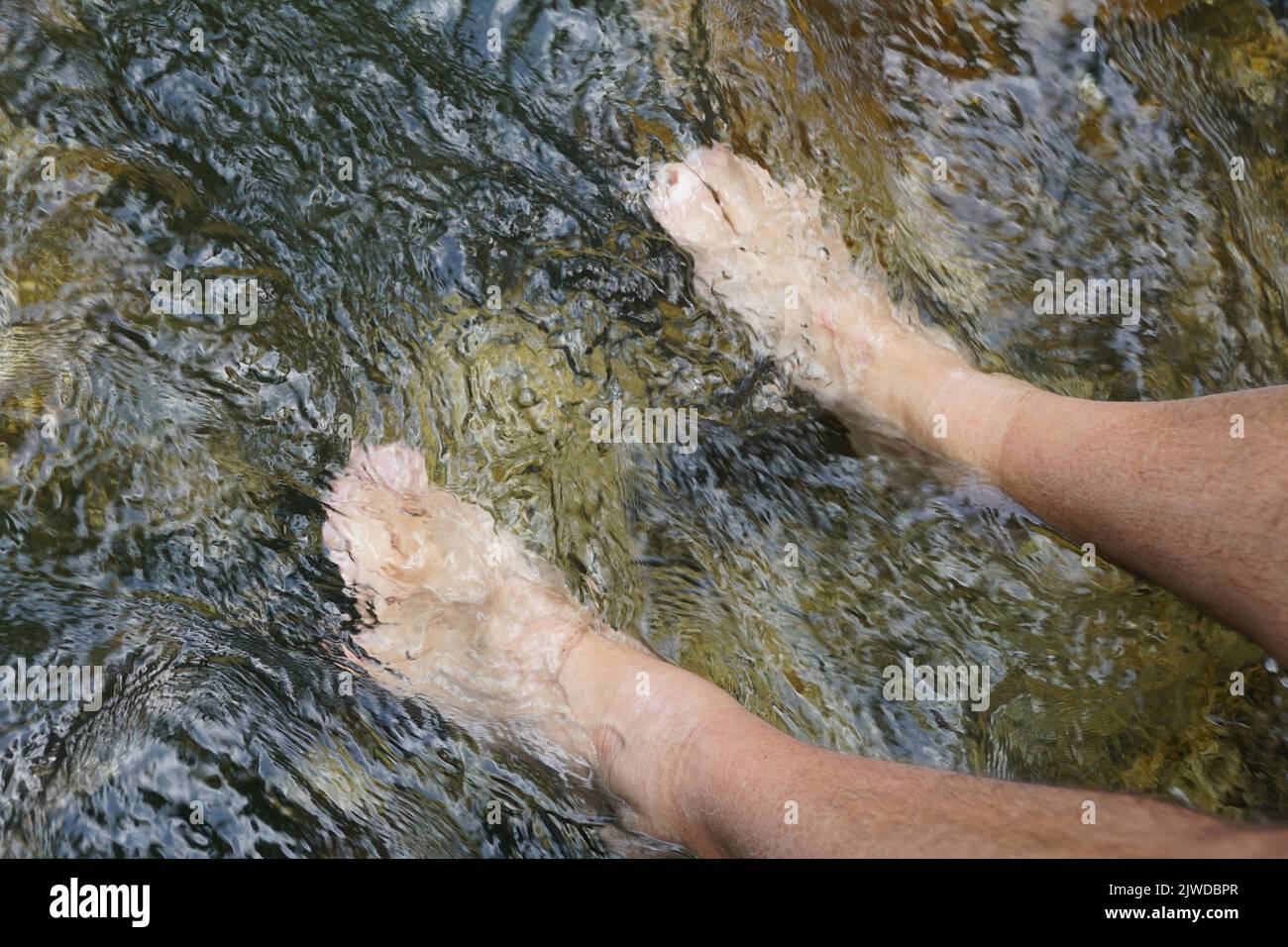 Dipping toes in the beautiful blue water of a natural spring near Blue Spring Heritage Center, Eureka Springs, Arkansas, U.S.A Stock Photo
