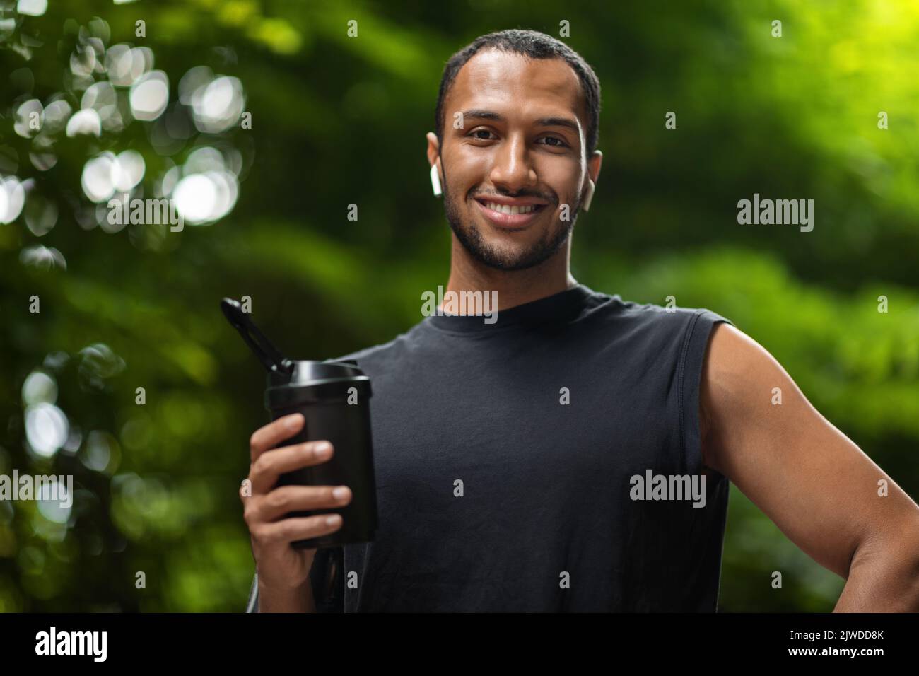Cheerful middle eastern sportsman holding protein drink Stock Photo - Alamy