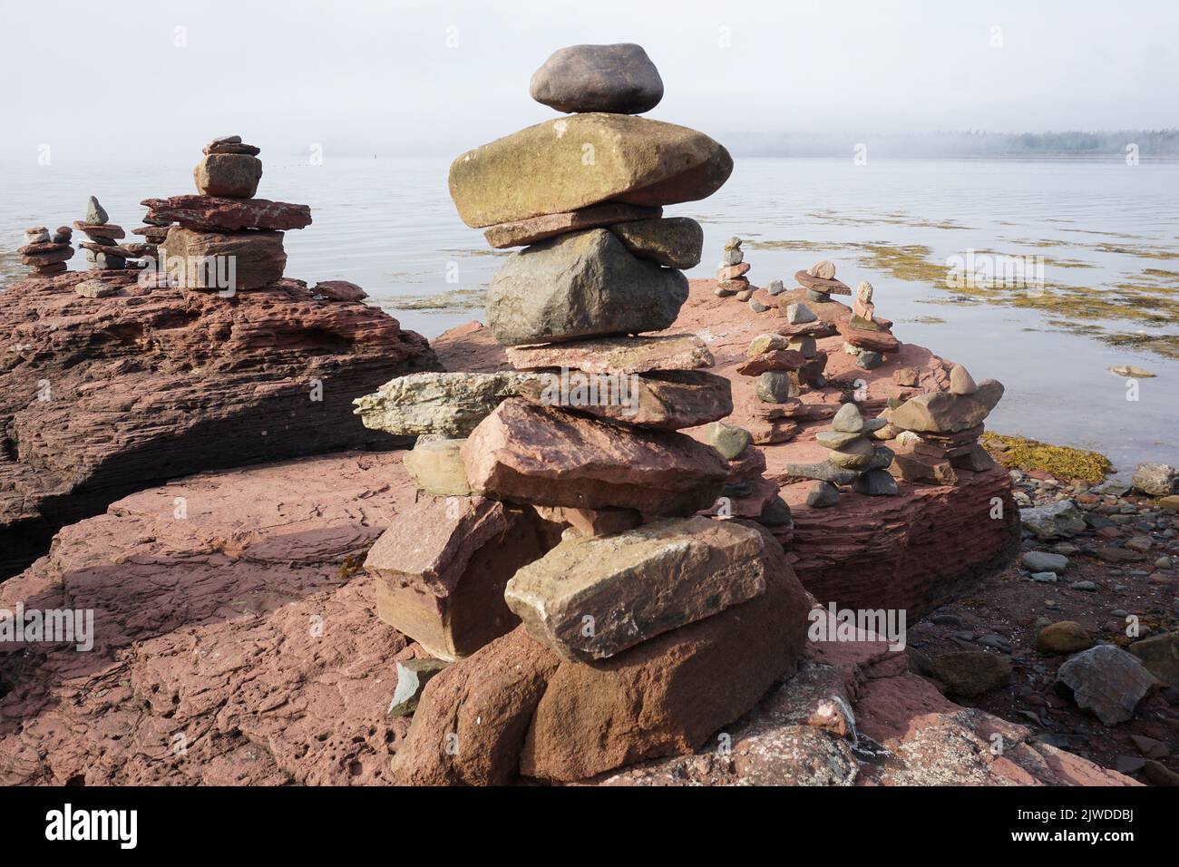 Inuksuk (Inukshuk) stone sculptures on a rock in the Bay of Fundy Stock Photo