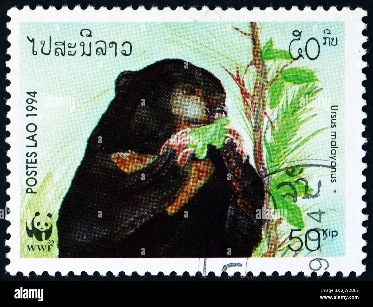 LAOS - CIRCA 1994: a stamp printed in Laos shows sun bear, ursus malayanus, is a species in the family ursidae occuring in the tropical forests od Sou Stock Photo