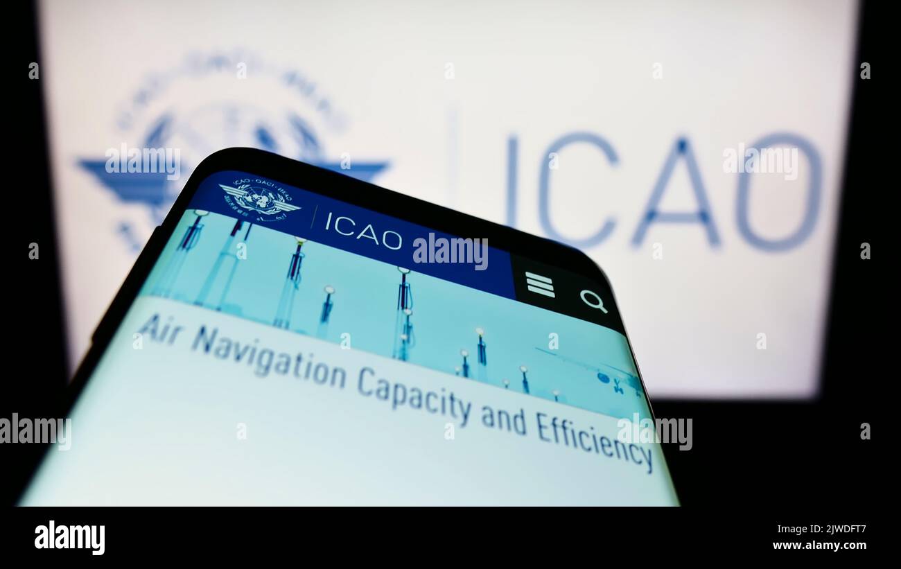 Smartphone with webpage of International Civil Aviation Organization (ICAO) on screen in front of logo. Focus on top-left of phone display. Stock Photo