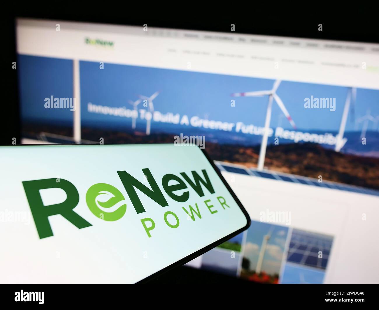 Mobile phone with logo of Indian company ReNew Energy Global plc on screen in front of business website. Focus on center-right of phone display. Stock Photo