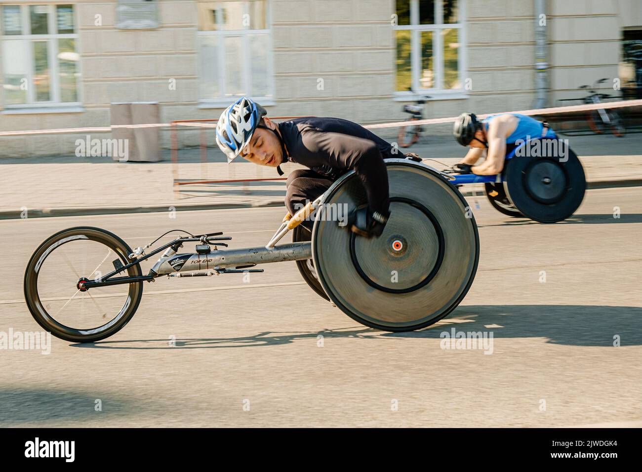 Ekaterinburg, Russia - August 7, 2022: male wheelchair racers moving down street in Europe-Asia Marathon Stock Photo