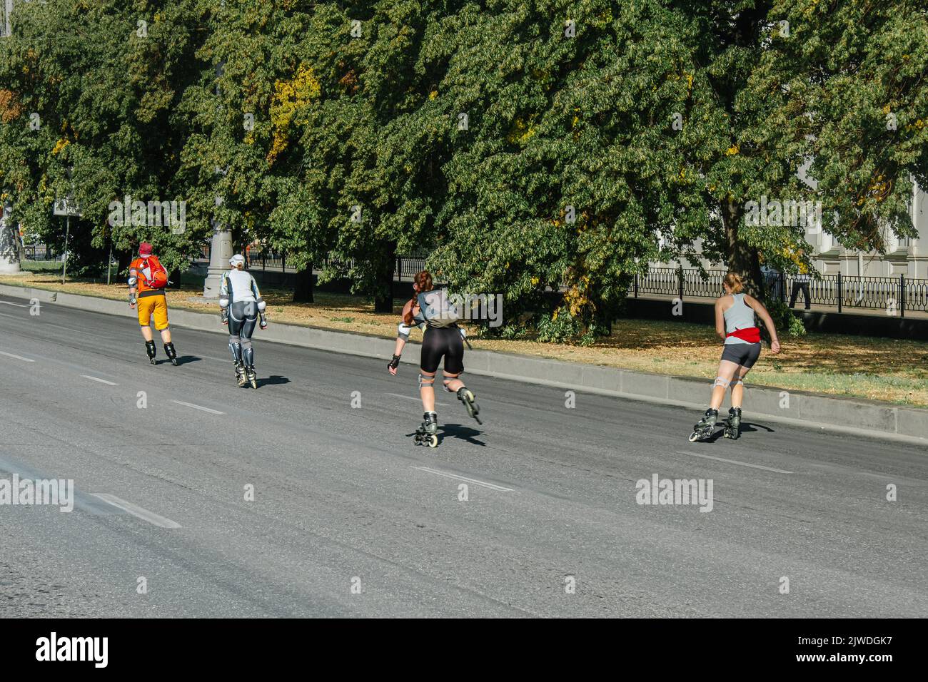 Ekaterinburg, Russia - August 7, 2022: man and women rollerblading on city street Stock Photo