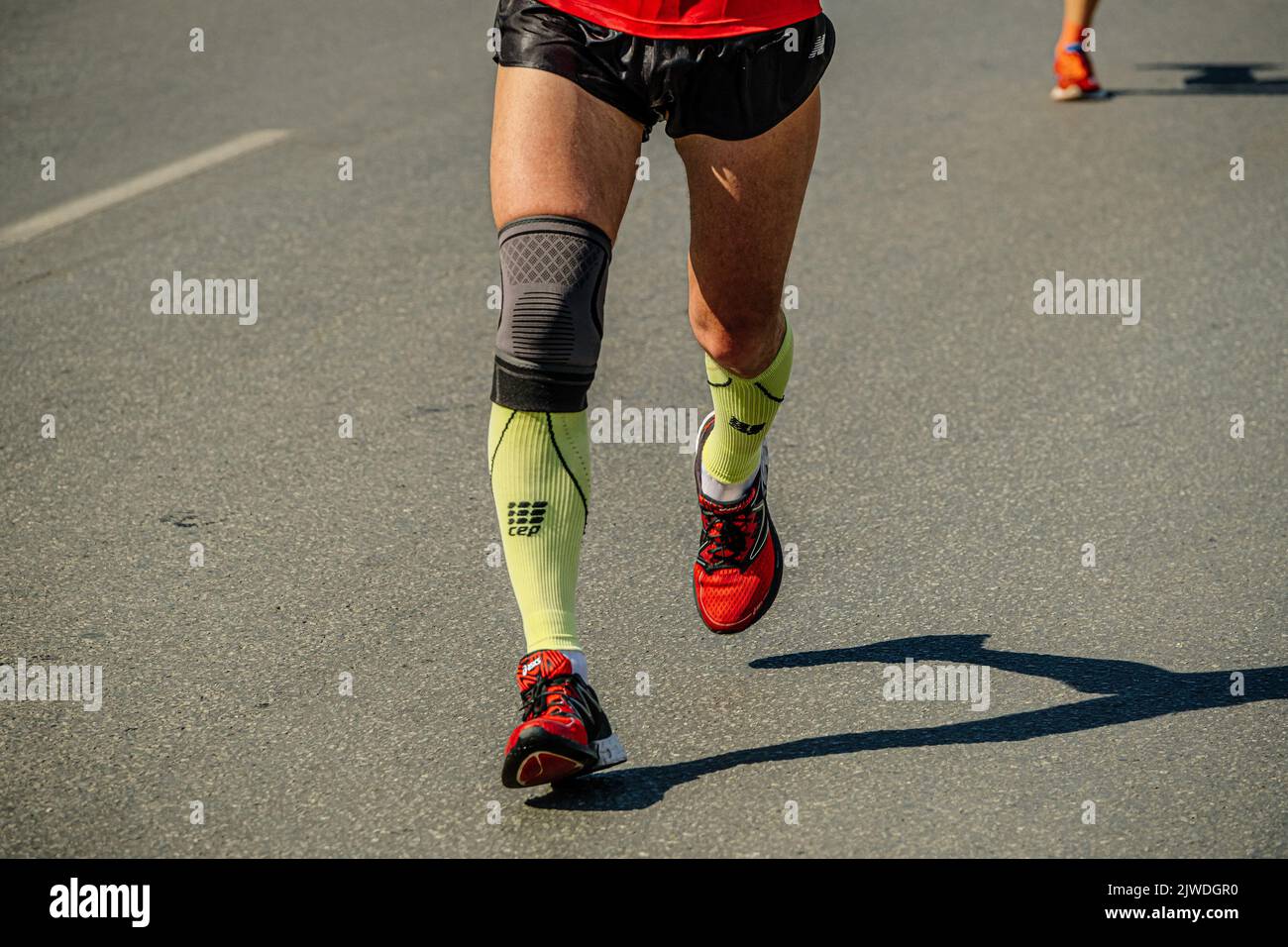 Ekaterinburg, Russia - August 7, 2022: legs runner athlete in knee pad run in Europe-Asia Marathon Stock Photo