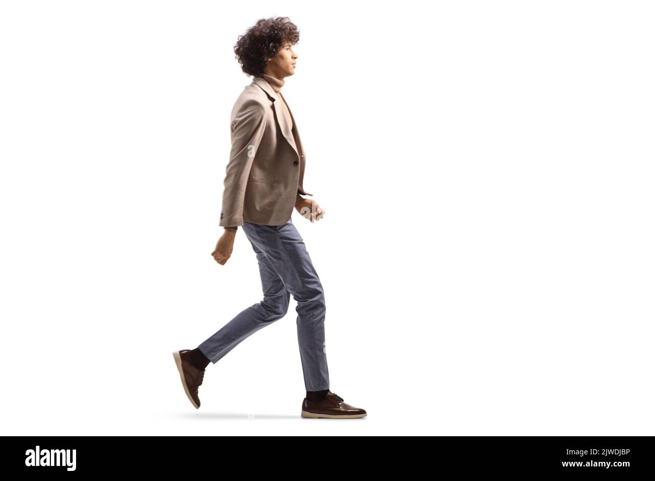 Full length profile shot of a tall man with a curly hair walking isolated on white background Stock Photo