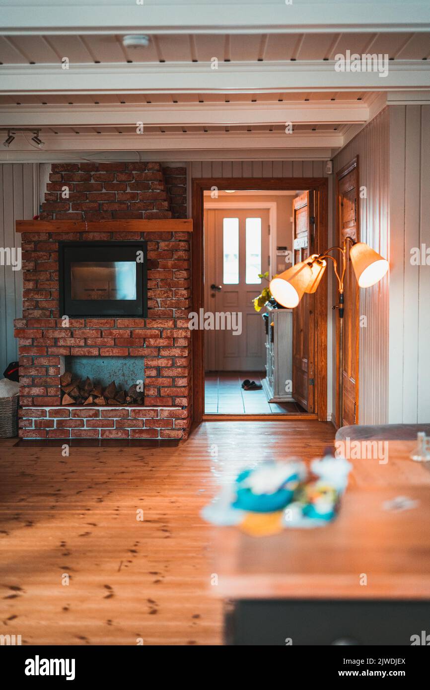 A vertical shot of a room with a red brick fireplace. Stock Photo