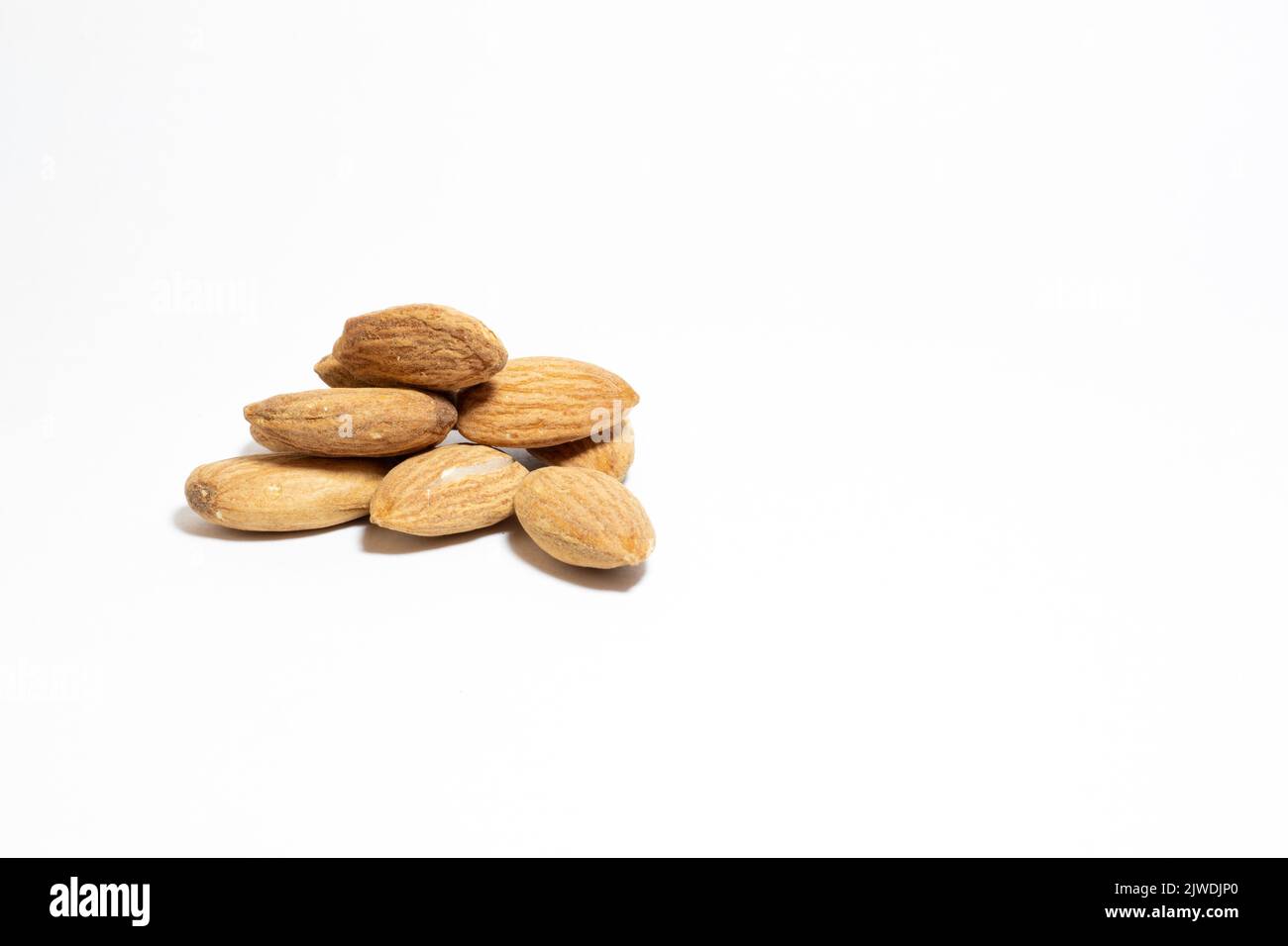 Group almonds isolated on white background. Pile of roasted almonds. Healthy food idea concept. Copy space, space for text. Empty area. No people. Stock Photo