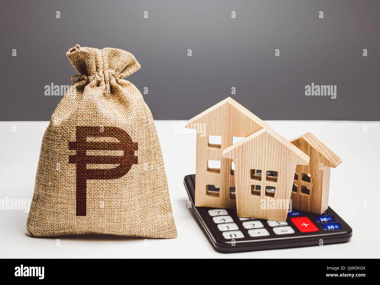 Houses on a calculator and philippine peso money bag. Realty or rental business. Buying and selling. Building maintenance. Real estate valuation. Mort Stock Photo