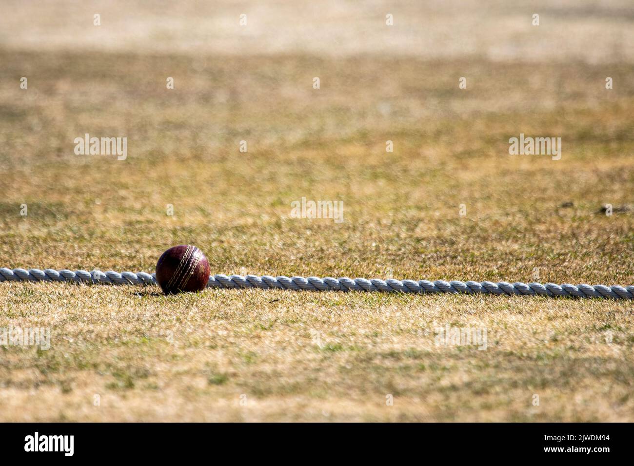 a cricket ball sitting on the boundary rope in hot dry weather Stock ...