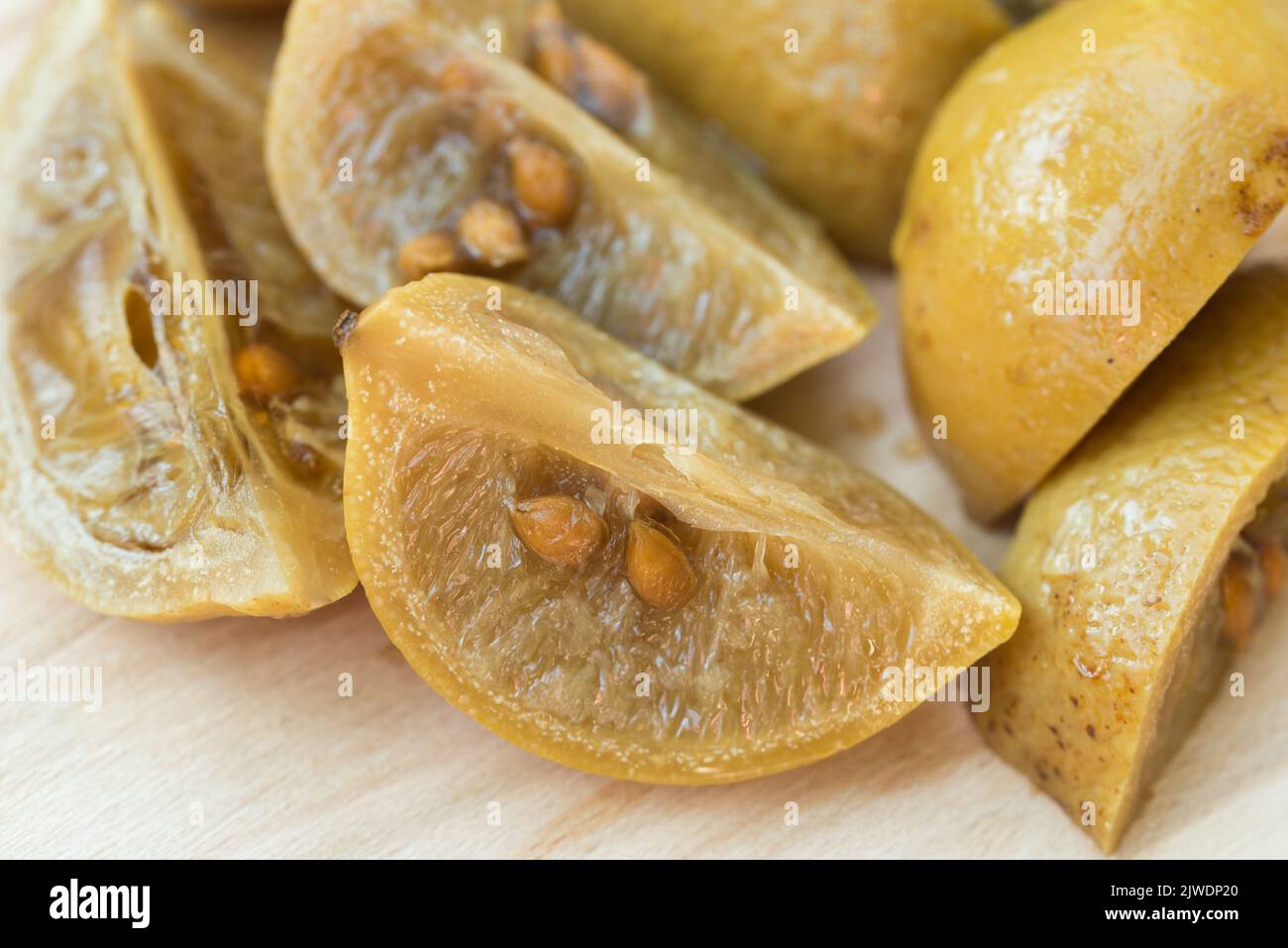 preserved lemons on wooden board closeup selective focus Stock Photo