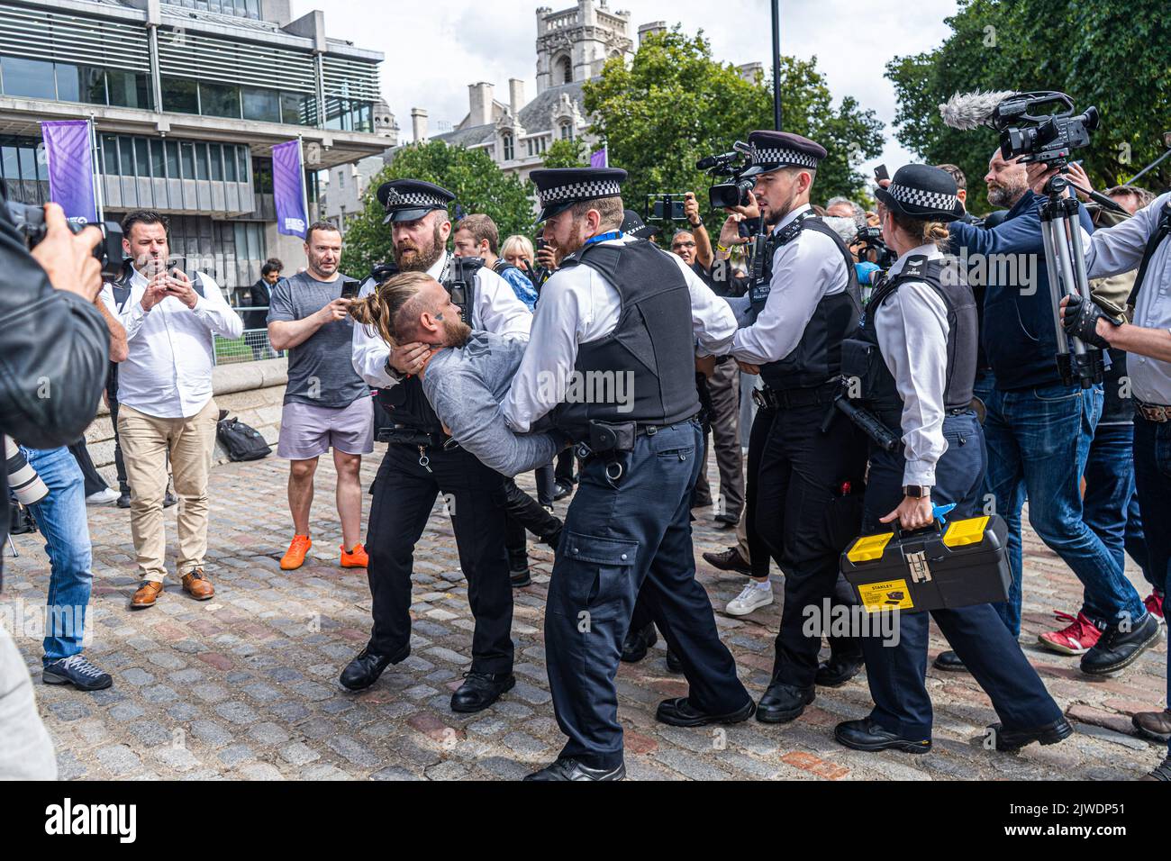 London UK. 5 September 2022.  An animal rebellion protester is carried away by police officers after staging a sit and blocking the road opposite the Queen Elizabeth II centre before   Liz Truss is announced as the new Conservative party leader and prime minister elect. Credit amer ghazzal/Alamy Live News Stock Photo