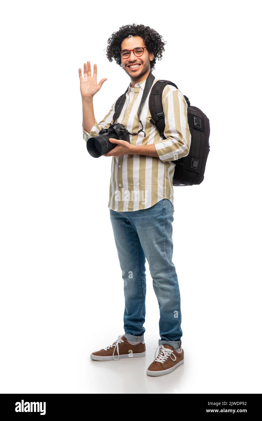 smiling male photographer with camera waving hand Stock Photo