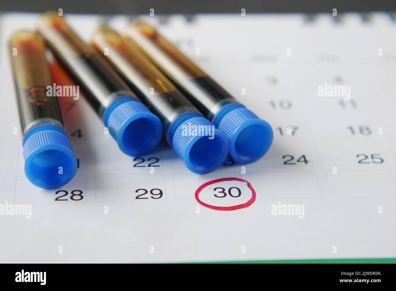 blood test tube and calendar on table Stock Photo Alamy