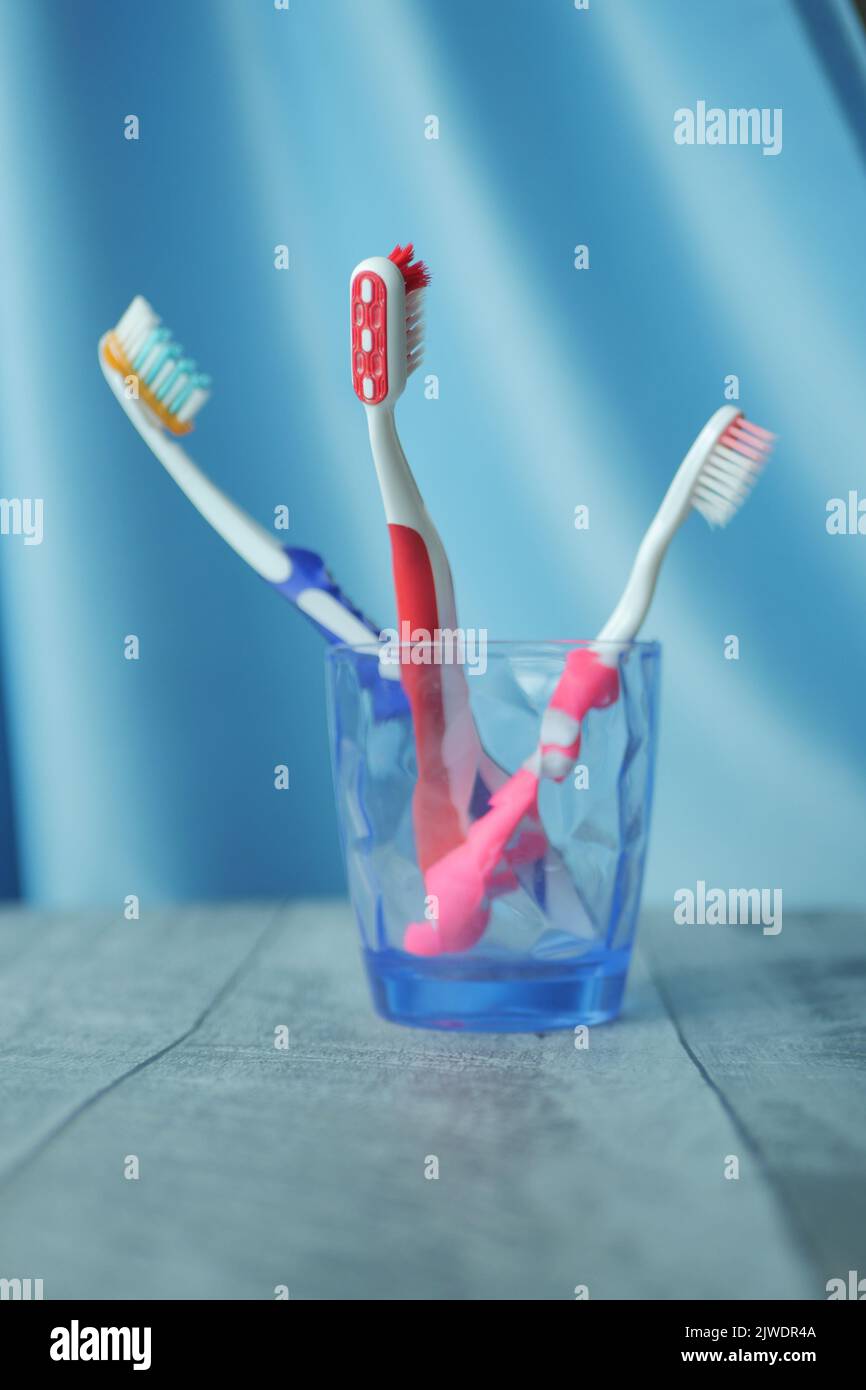 colorful toothbrushes in white mug against a wall Stock Photo - Alamy