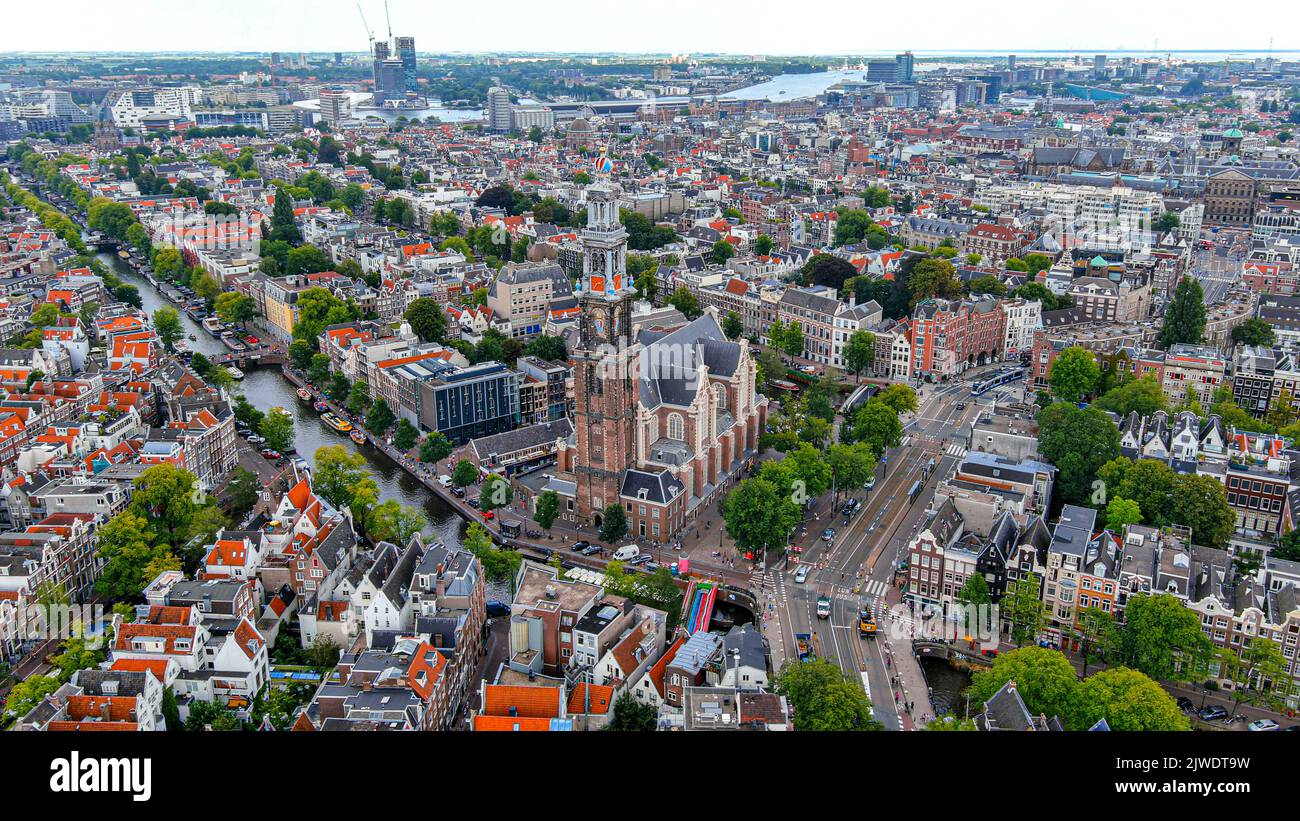 Beautiful aerial Amsterdam view from above, Netherlands ft. drone view of Westerkerk church and narrow canal with bridge, street, boats, architectures Stock Photo