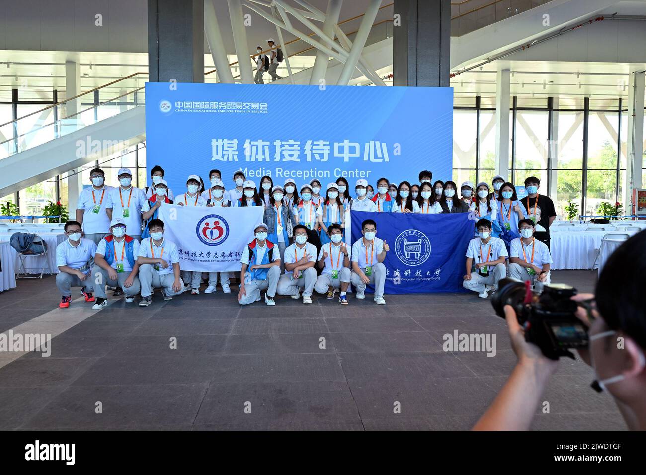 (220905) -- BEIJING, Sept. 5, 2022 (Xinhua) -- Volunteers pose for a group photo at the media reception center of  the Shougang Park during the 2022 China International Fair for Trade in Services (CIFTIS) in Beijing, capital of China, Sept. 5, 2022. The 2022 CIFTIS closed on Monday. (Xinhua/Li Xin) Stock Photo