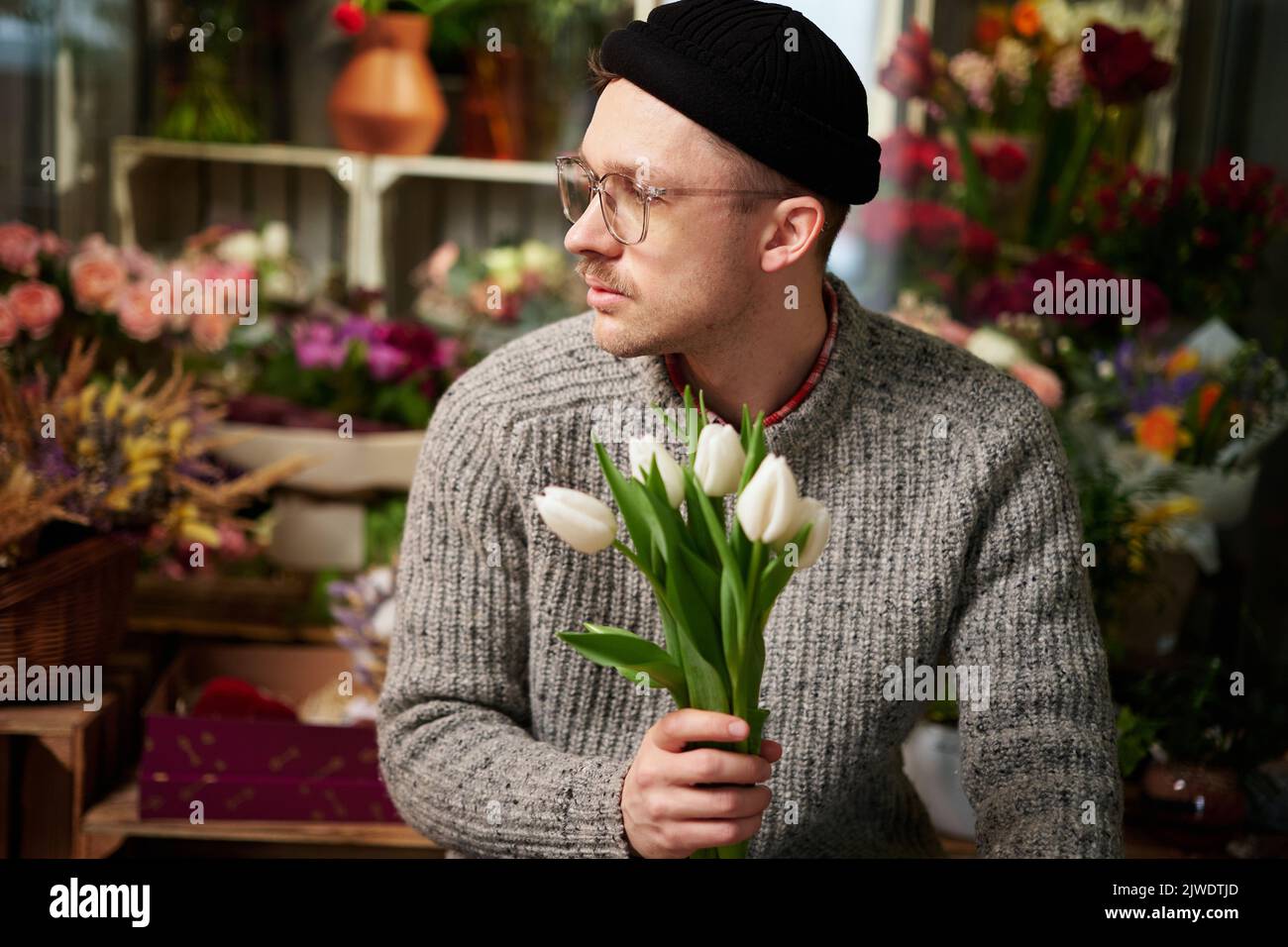 Spring gift. Bearded man hipster with flowers. Bearded man with tulip  bouquet. Flower for March 8. Love date. international holiday. Womens day.  bearded man with happy face. flowers from bearded man Stock, image size:1300x956