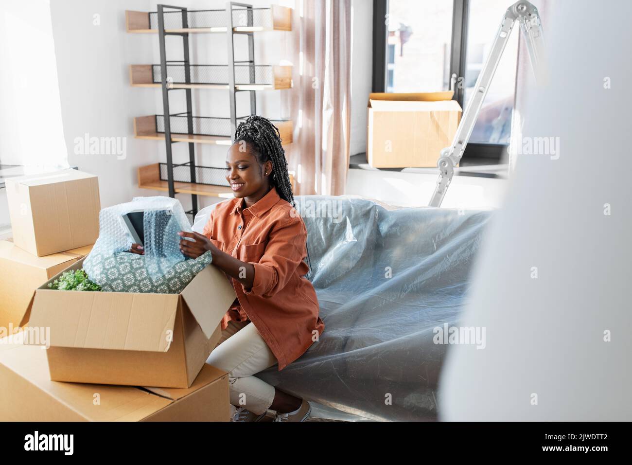 Happy woman packing boxes hi-res stock photography and images - Alamy