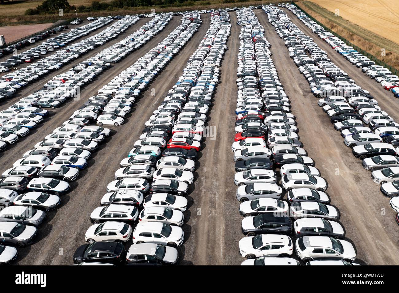 TAMWORTH, UK - AUGUST 30, 2022.  An aerial view of rows of newly built cars and vehicles ready for export and import and delivery to sales dealerships Stock Photo