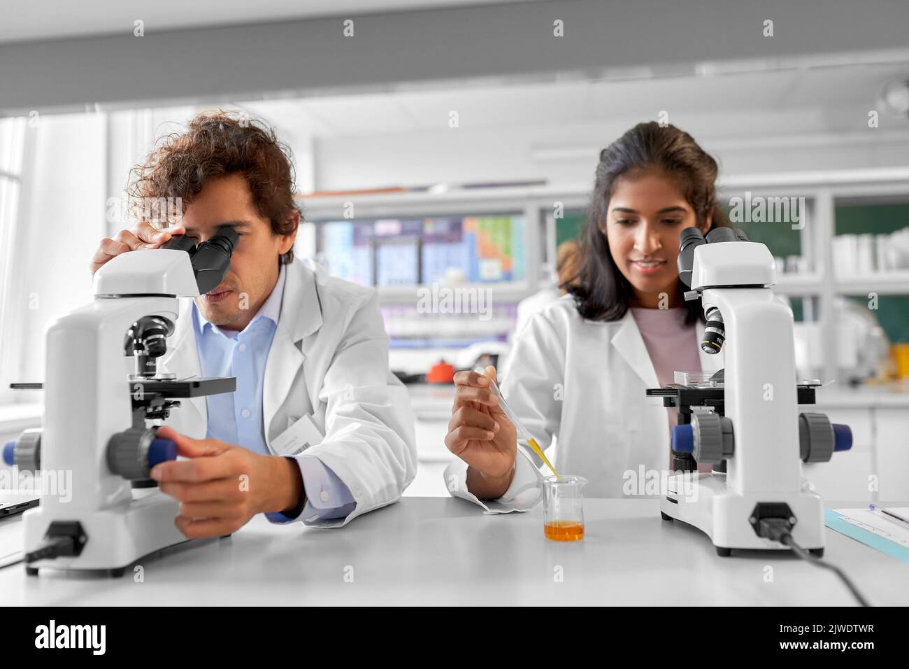 scientists with microscopes working in laboratory Stock Photo
