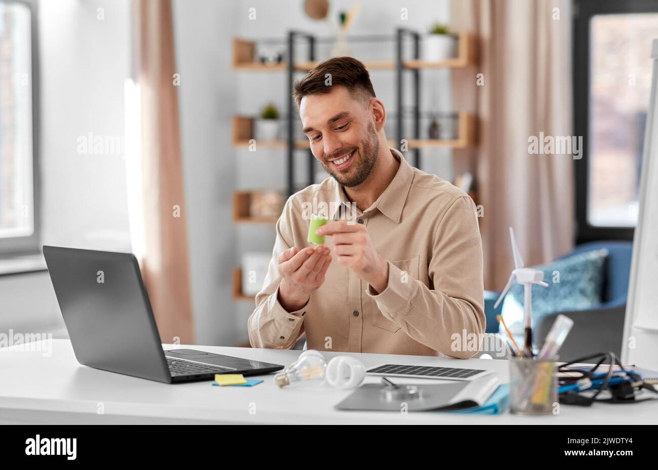 male teacher with laptop and battery at home Stock Photo