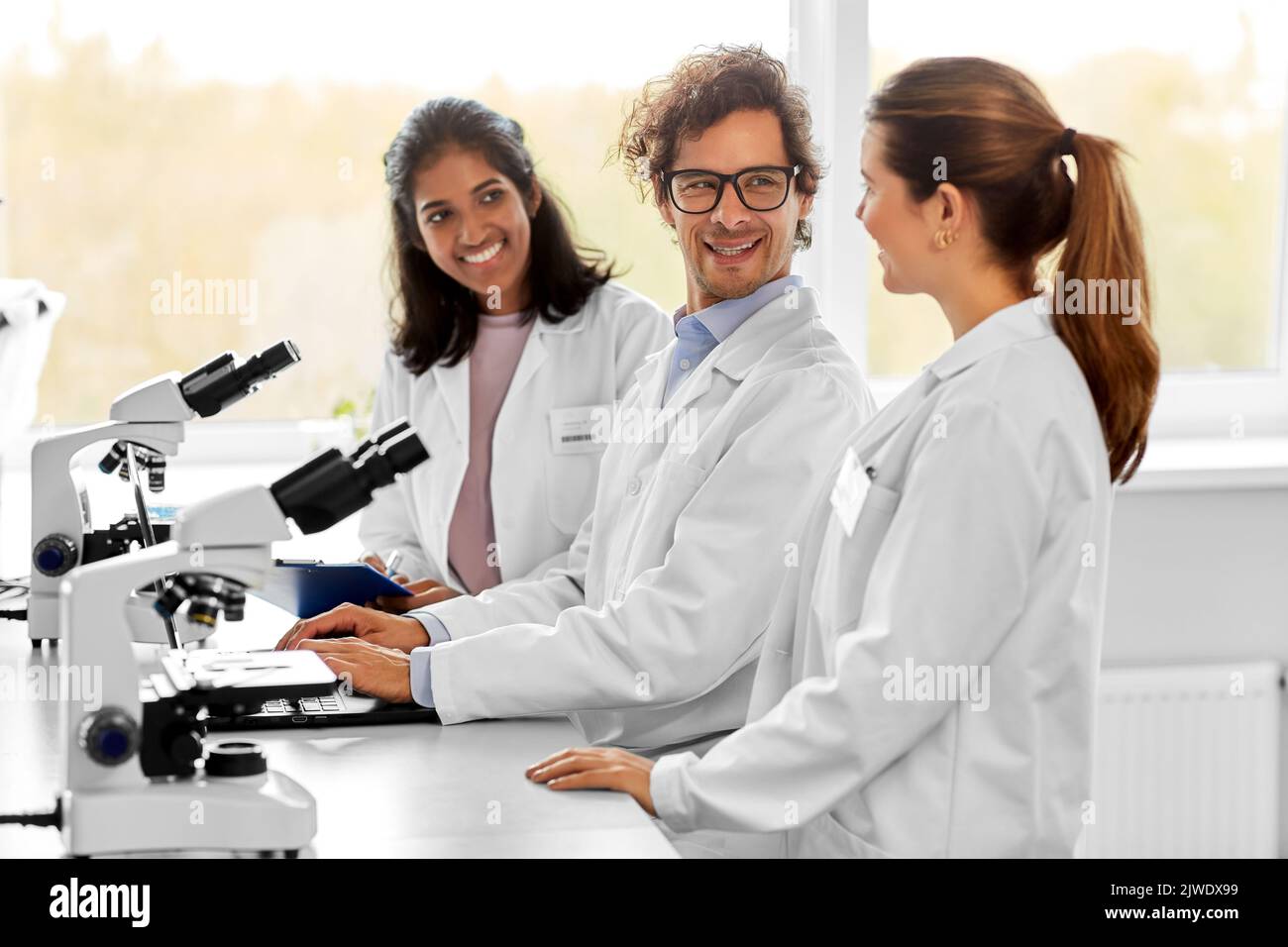 scientists with microscopes working in laboratory Stock Photo