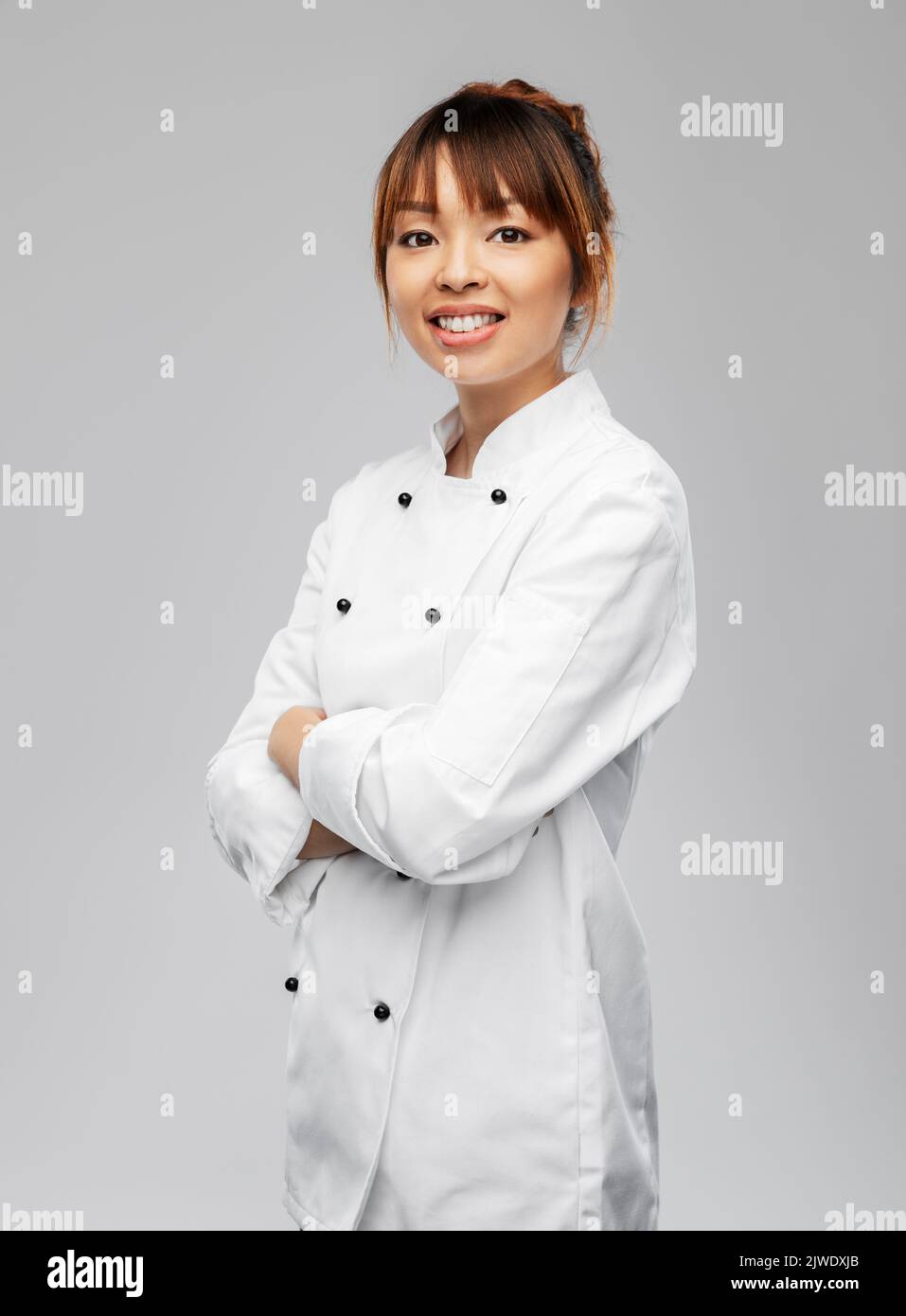 smiling female chef in white jacket Stock Photo