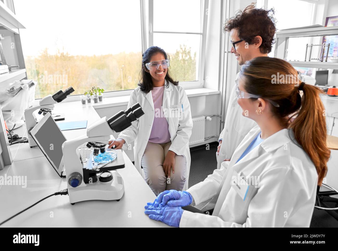 scientists with microscopes working in laboratory Stock Photo