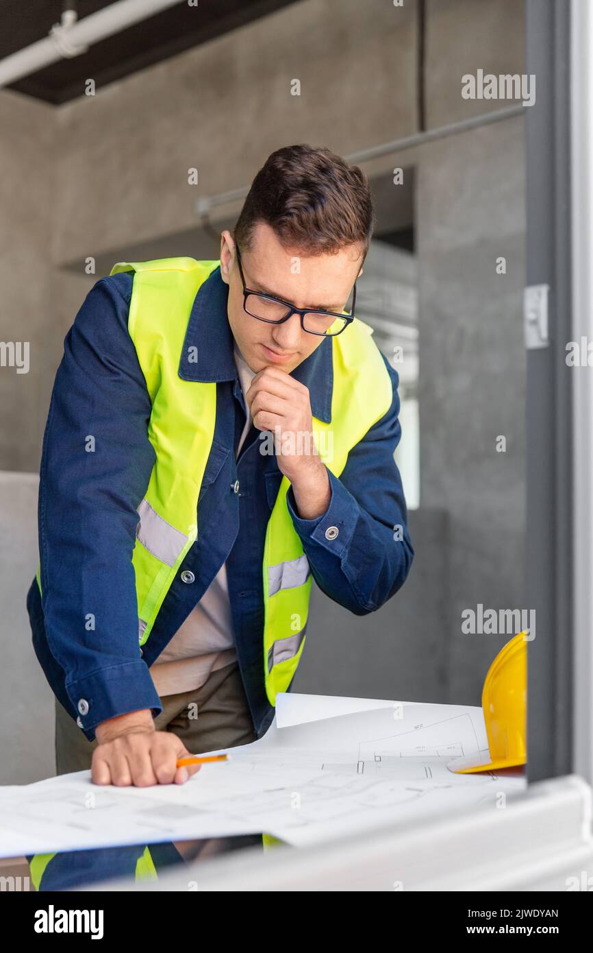 male architect with blueprint working at office Stock Photo