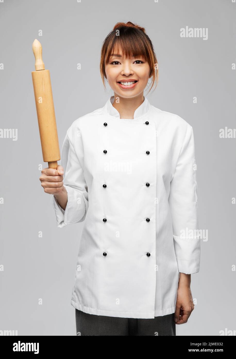 smiling female chef or baker with rolling pin Stock Photo