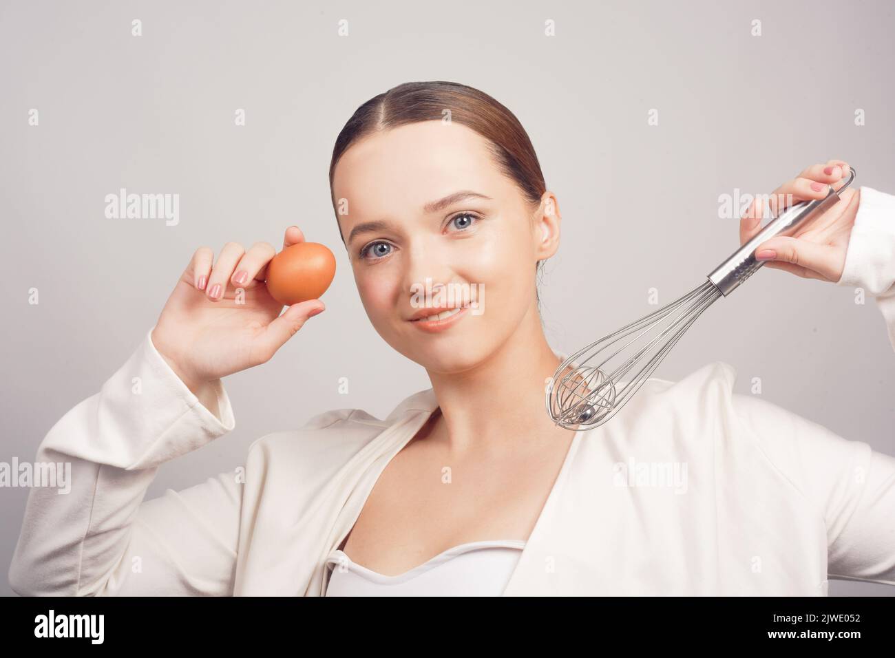 Chef girl, school of chefs in white background, balloon whisk and aggs