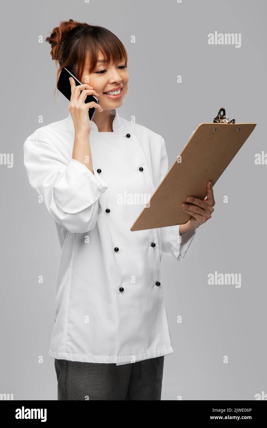 happy female chef with clipboard calling on phone Stock Photo - Alamy