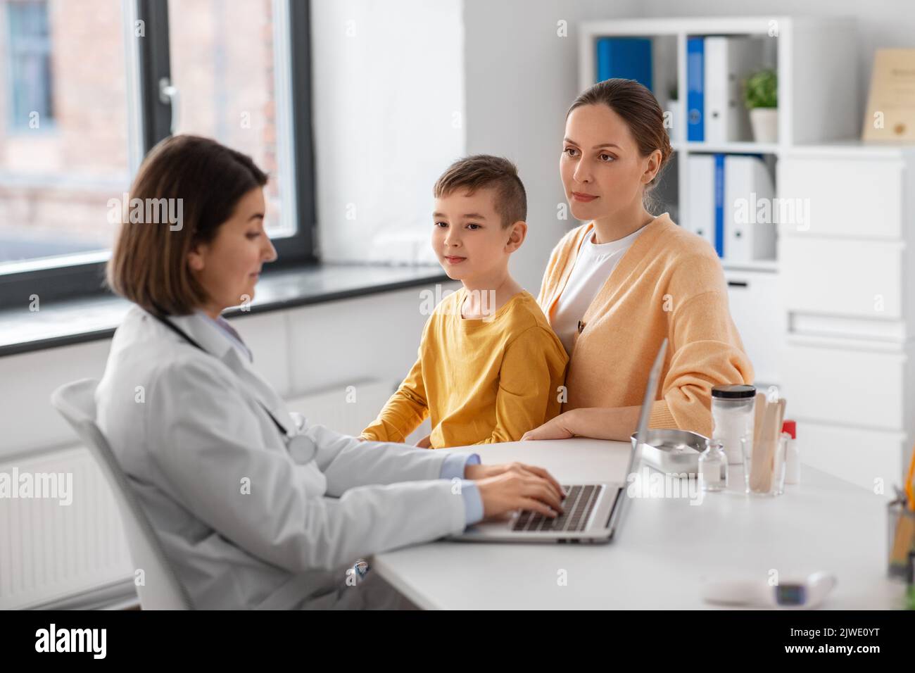 mother, son and doctor with laptop at clinic Stock Photo