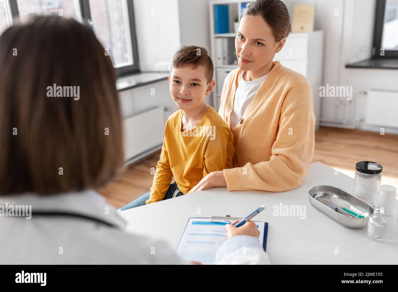 mother, son and doctor talking at clinic Stock Photo - Alamy
